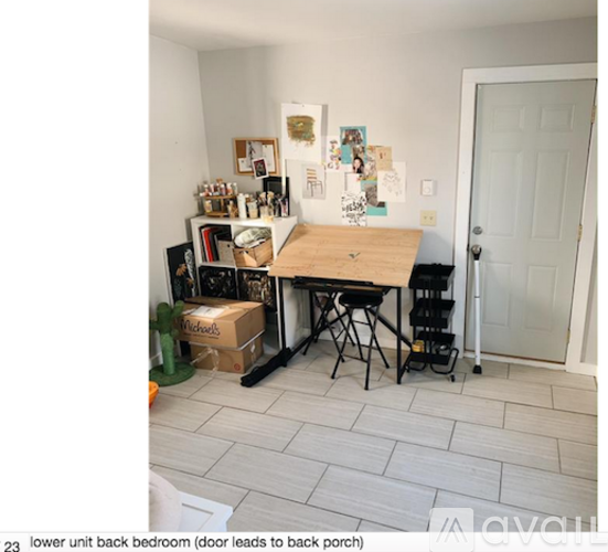 A small room with a table and chairs and a box on the floor.