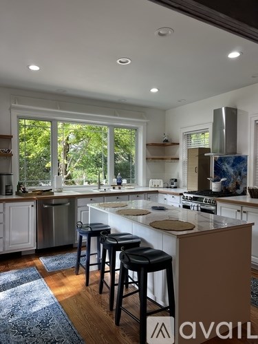 A kitchen with a large island and bar stools.