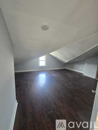 A room with wooden floors and a window letting in light.