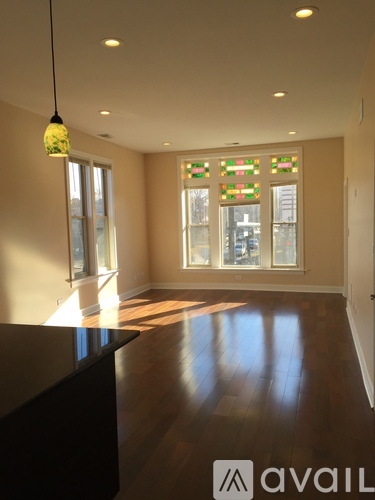A room with wooden floors and a large window with stained glass.