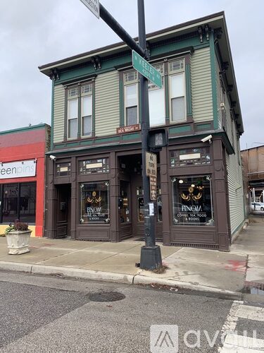 A street view of a building with a green sign on the corner.