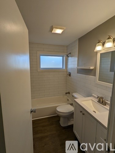 A bathroom with a toilet, sink, and tub.