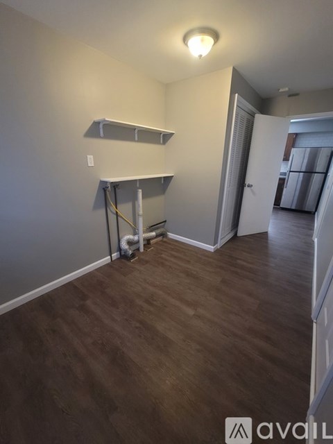 A room with a white wall and a wooden floor.