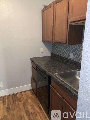 A kitchen with wooden cabinets and a checkered backsplash.