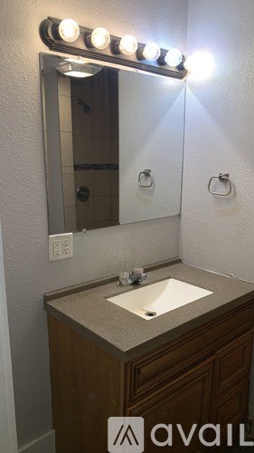A bathroom vanity with a mirror and lights above it.