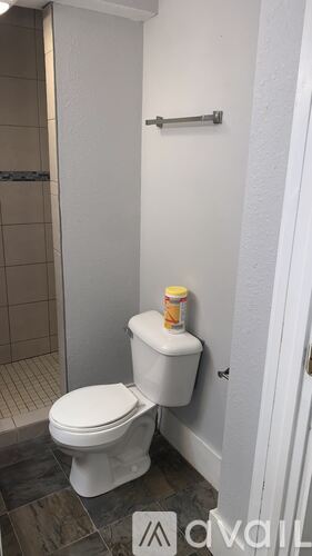 A white toilet with a yellow container on top of it.