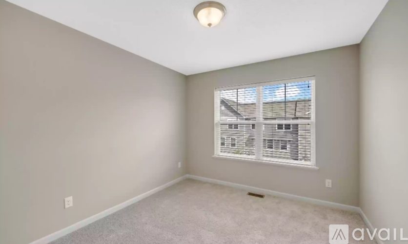 A room with a window and a carpeted floor.