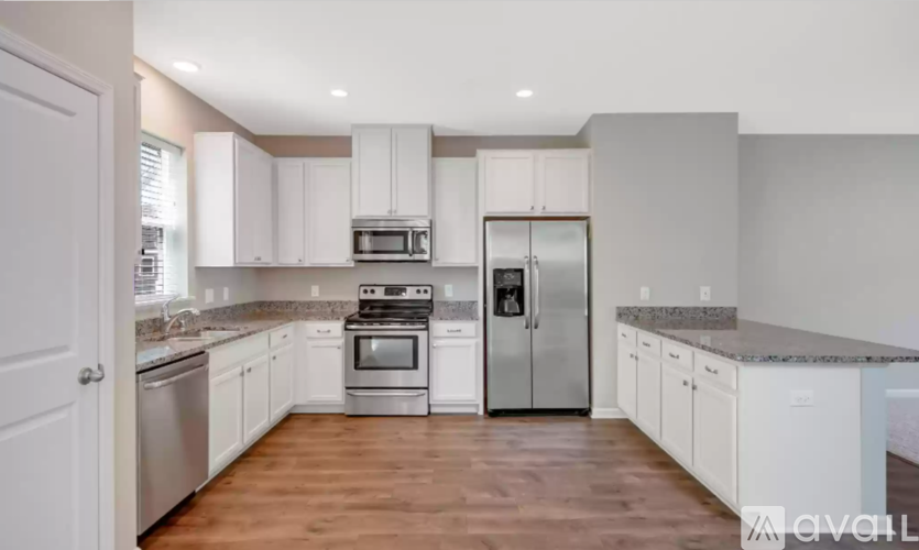 A kitchen with white cabinets and stainless steel appliances.