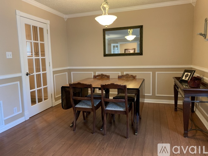 A dining room with a wooden table and chairs.