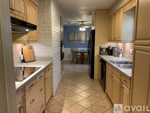 A kitchen with wooden cabinets and a black refrigerator.
