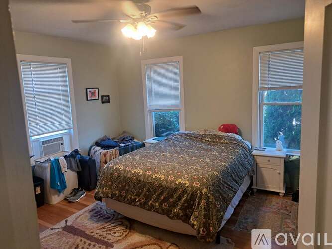 A bedroom with a bed covered in a shiny gold bedspread.
