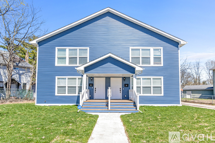 A blue house with a white door and windows.