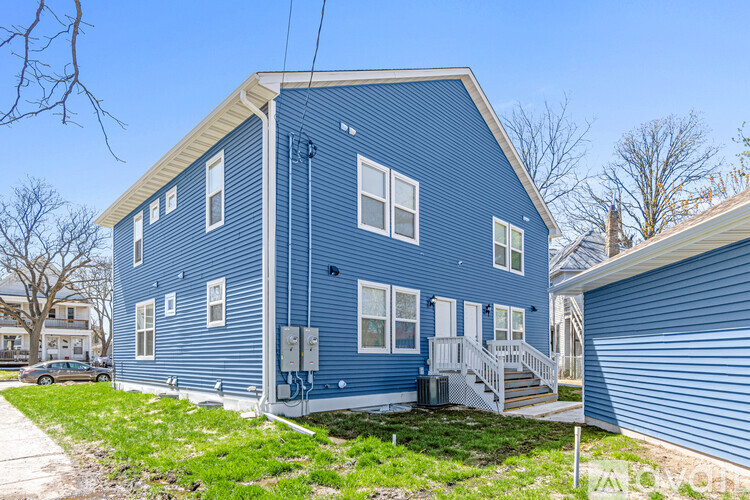 A blue house with a white door and windows.