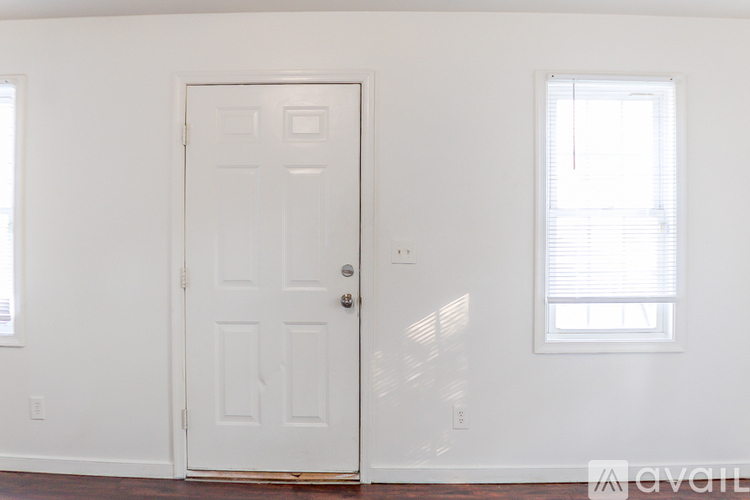 A white door is in a room with a window.