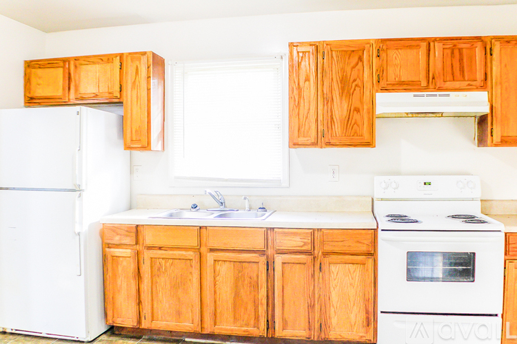 A kitchen with wooden cabinets and white appliances.