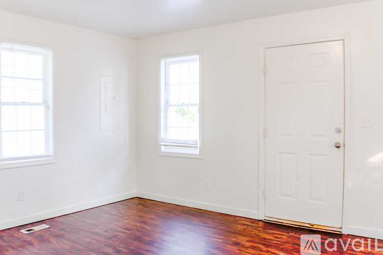A room with a wooden floor and white walls.