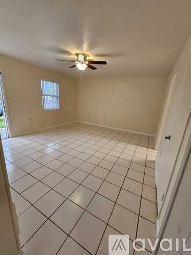 A room with a ceiling fan and tiled floor.