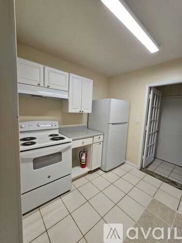 A kitchen with white appliances and cabinets.
