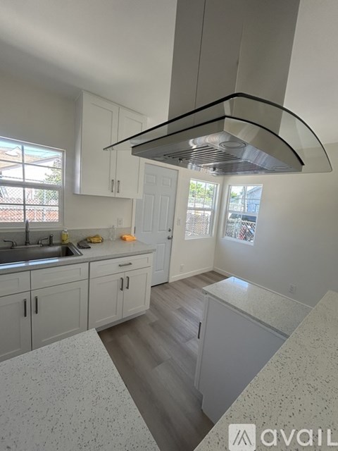A kitchen with white cabinets and a marble countertop.