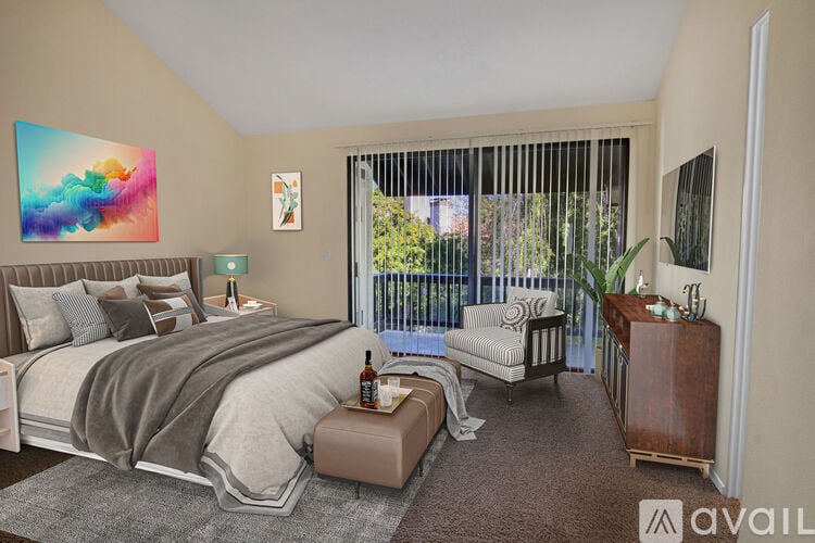 A bedroom with a large bed and a painting on the wall.