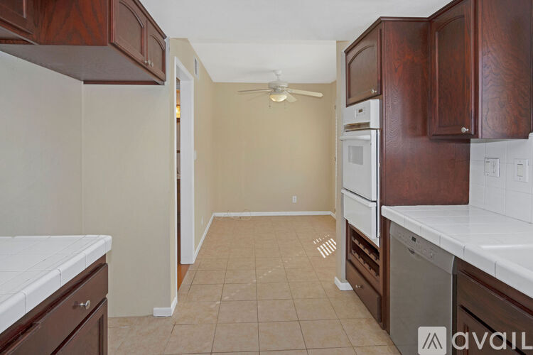 A kitchen with brown cabinets and a white counter top.