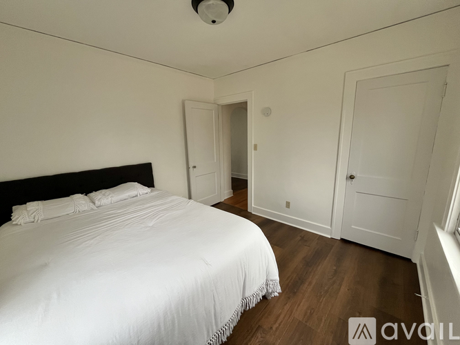 A bedroom with a large bed and a smoke detector on the ceiling.