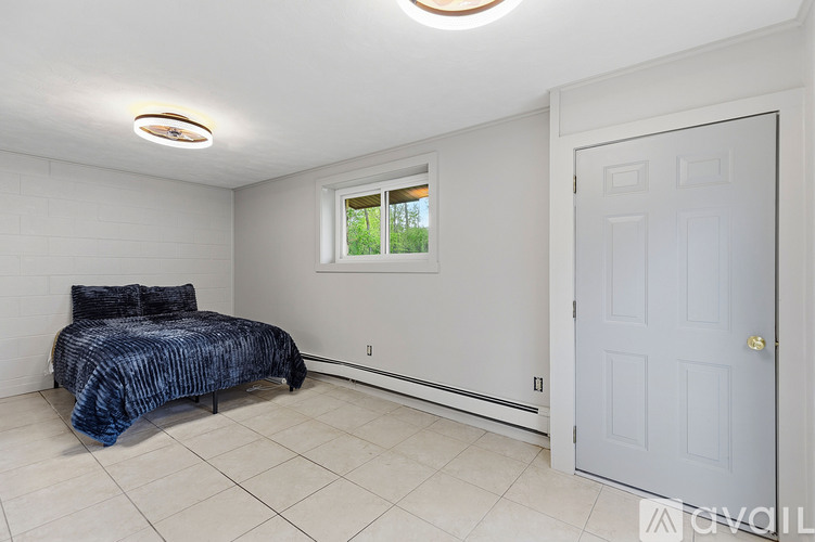A bedroom with a bed and a window.