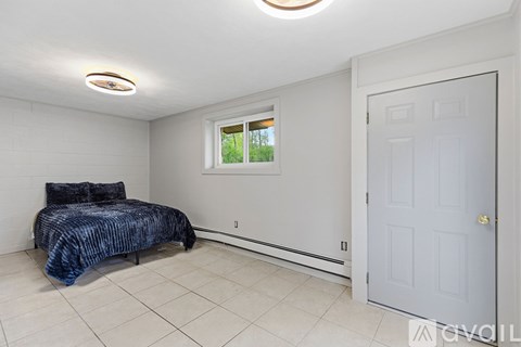 A bedroom with a bed and a window.