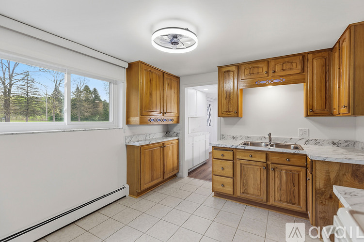 A kitchen with wooden cabinets and a marble countertop.