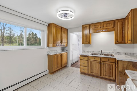 A kitchen with wooden cabinets and a marble countertop.