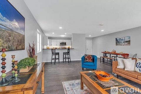 A living room with a blue chair and a wooden coffee table.