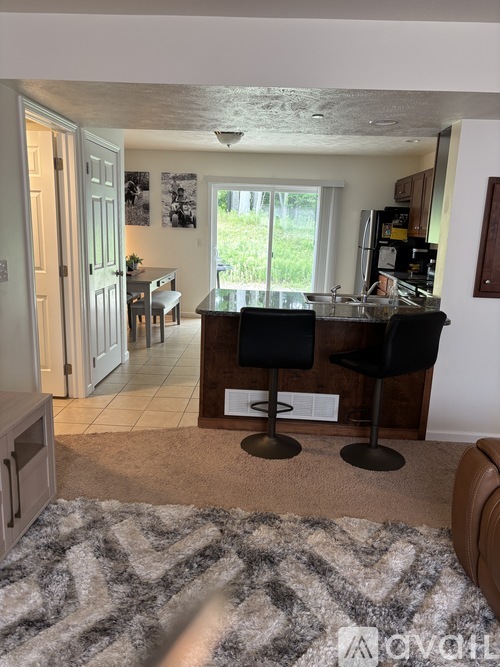A kitchen with a bar stool in front of it.