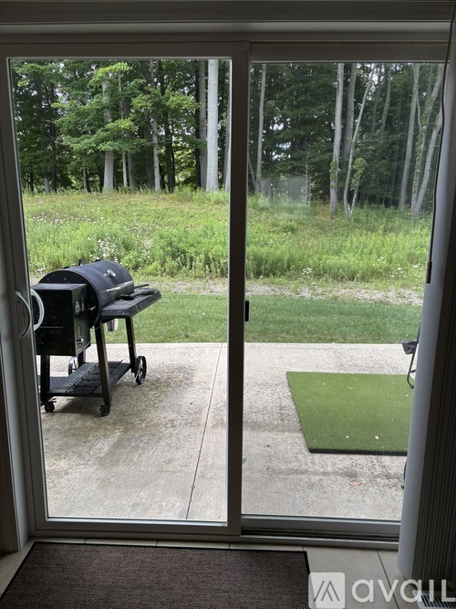 A black chair is on a black cart outside a sliding glass door.