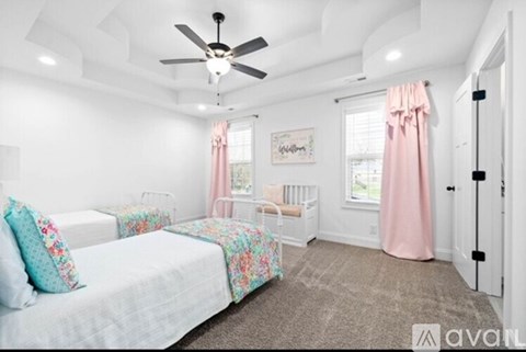 A bedroom with a white bed and a pink curtain.