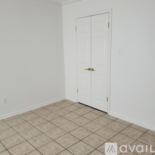 A room with a white door and tiled floor.