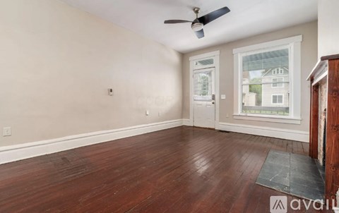 A room with a ceiling fan and a window with a view of a building outside.