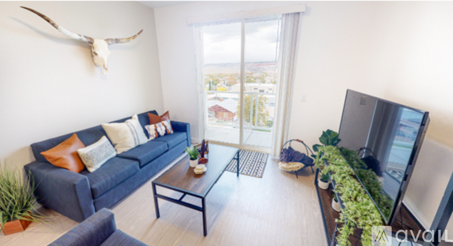 A living room with a blue couch and a flat screen TV.
