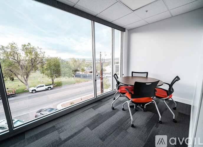 A conference room with a table and chairs and a view of the street outside.