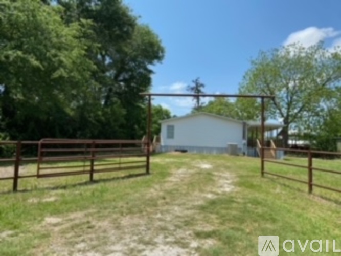 A house is behind a gate in a grassy area.