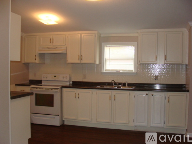 A kitchen with white cabinets and a black countertop.