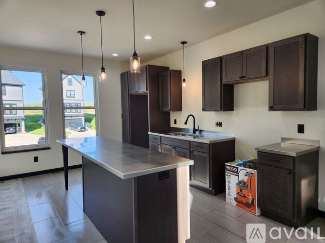 A modern kitchen with dark brown cabinets and a large island.