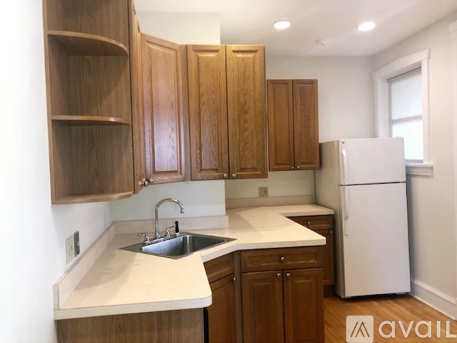 A kitchen with wooden cabinets and a white refrigerator.
