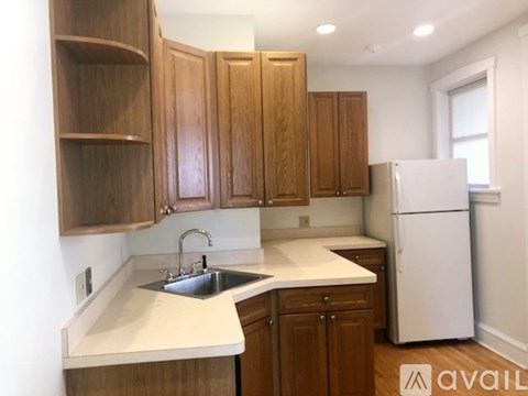 A kitchen with wooden cabinets and a white refrigerator.