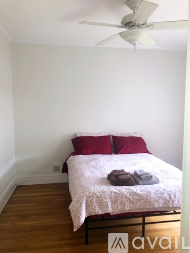 A bedroom with a bed and a ceiling fan.