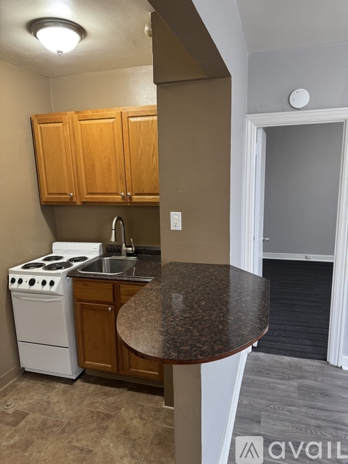 A kitchen with a white stove and wooden cabinets.