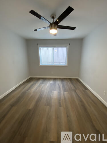 A room with wooden flooring and a ceiling fan.