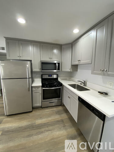 A kitchen with white cabinets and stainless steel appliances.