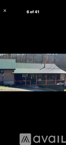 A building with a green roof and a sign that says "avail" in front of it.