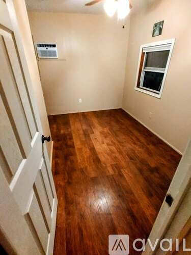 A room with wooden floors and a window.