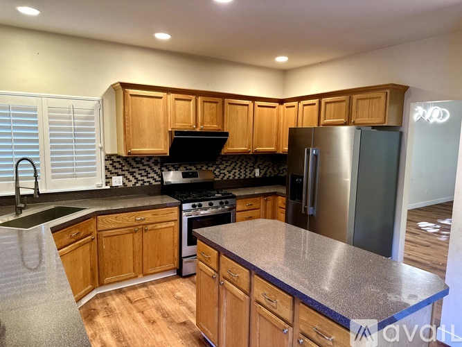 A kitchen with wooden cabinets and a black stove top oven.